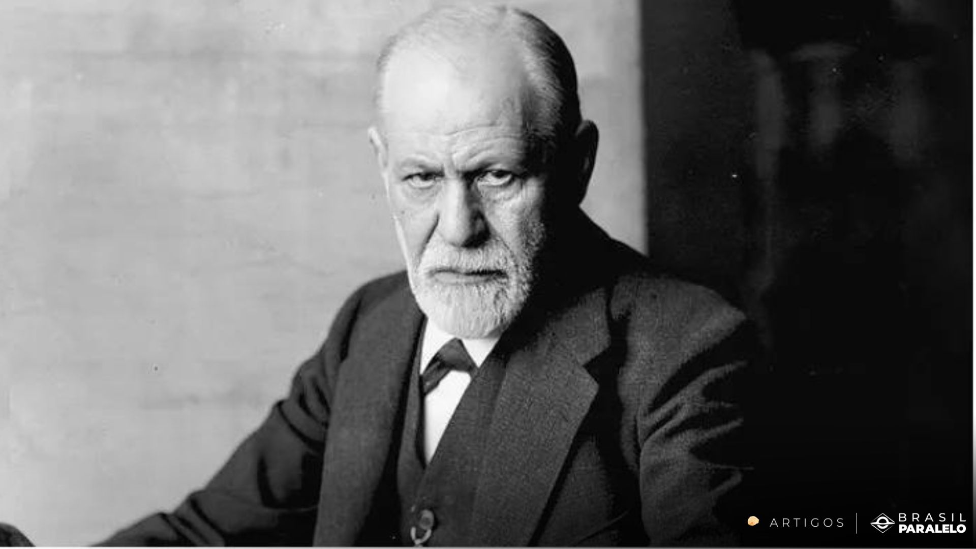 A potrait of the founding fathers of psycology Sigmund Freud looking at the camera in a serious look.
